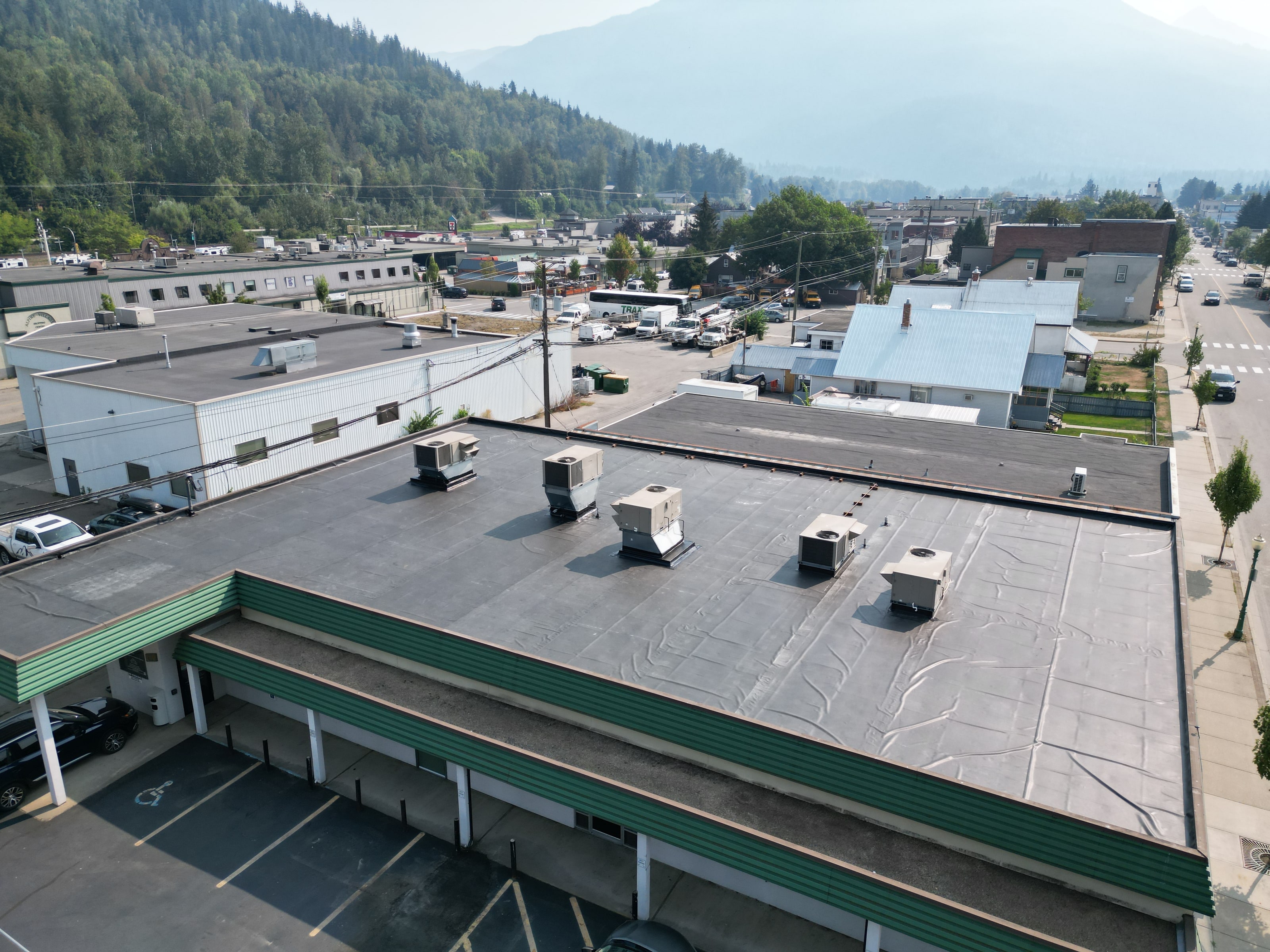 A finished EPDM roof on a commercial building, the town and hills beyond