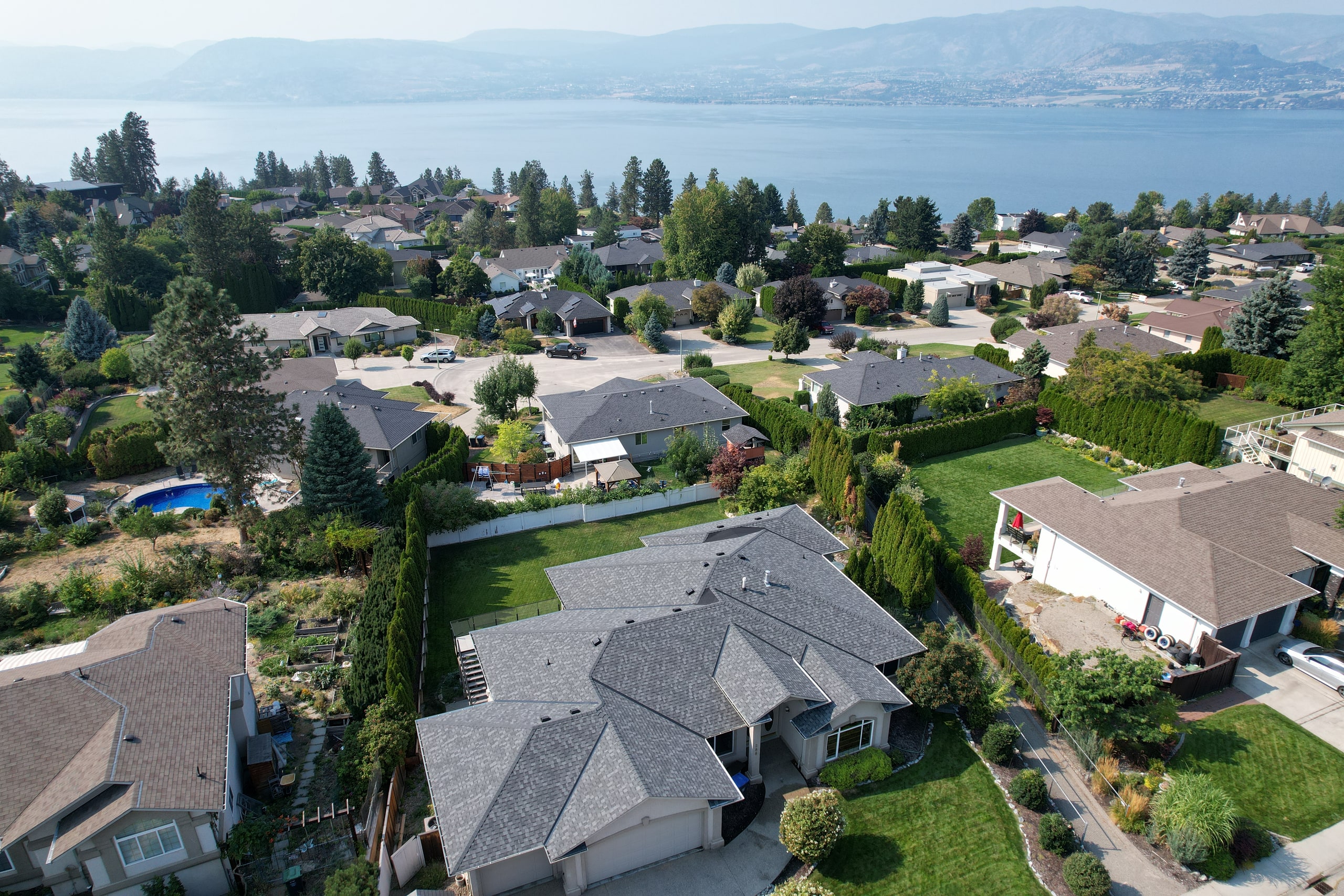 An architectural shingle re-roof in a lakeside neighbourhood, seen from the air