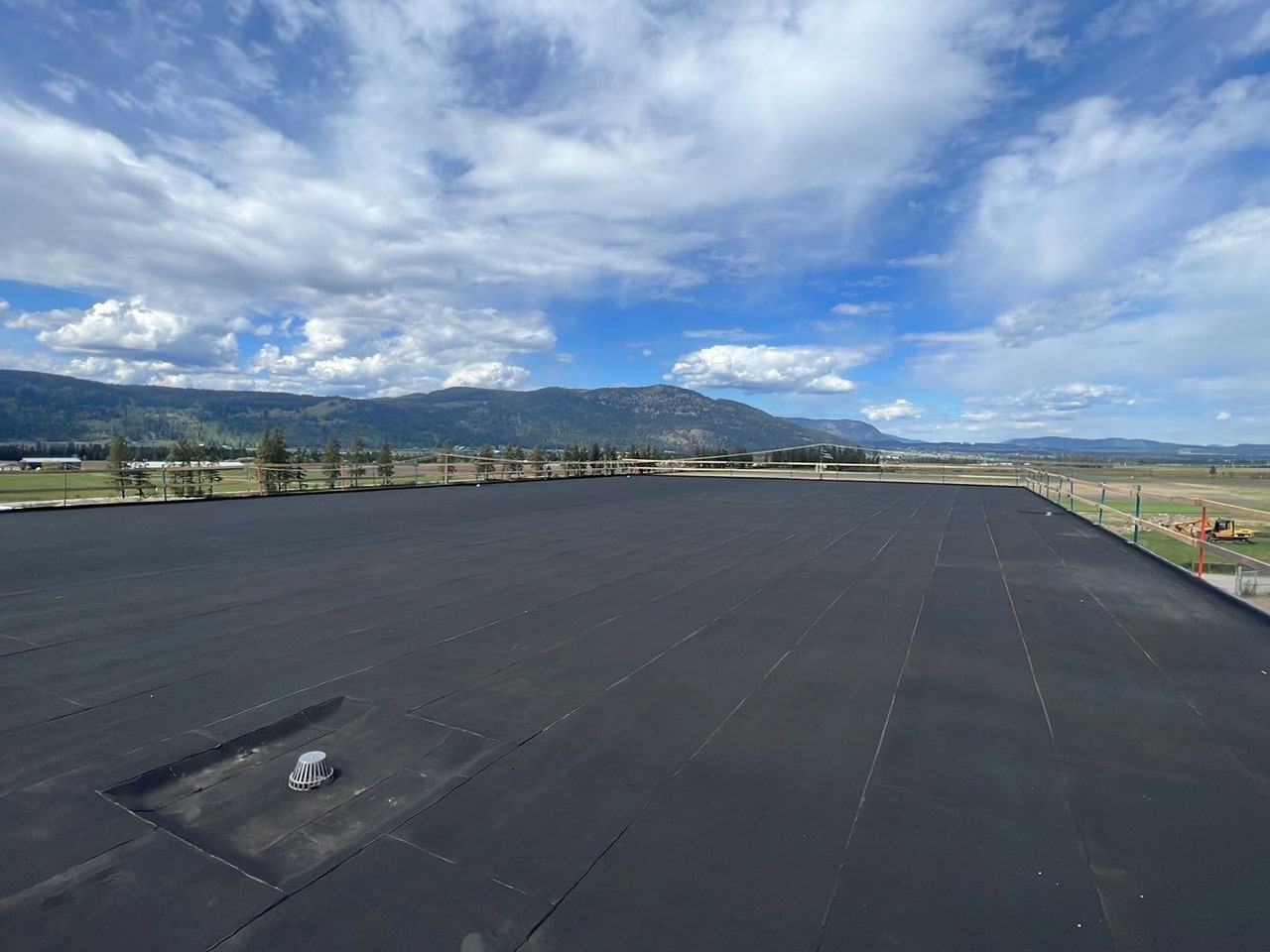 A new copper drain in the finished two-ply torch-on roof, the valley and the mountains beyond