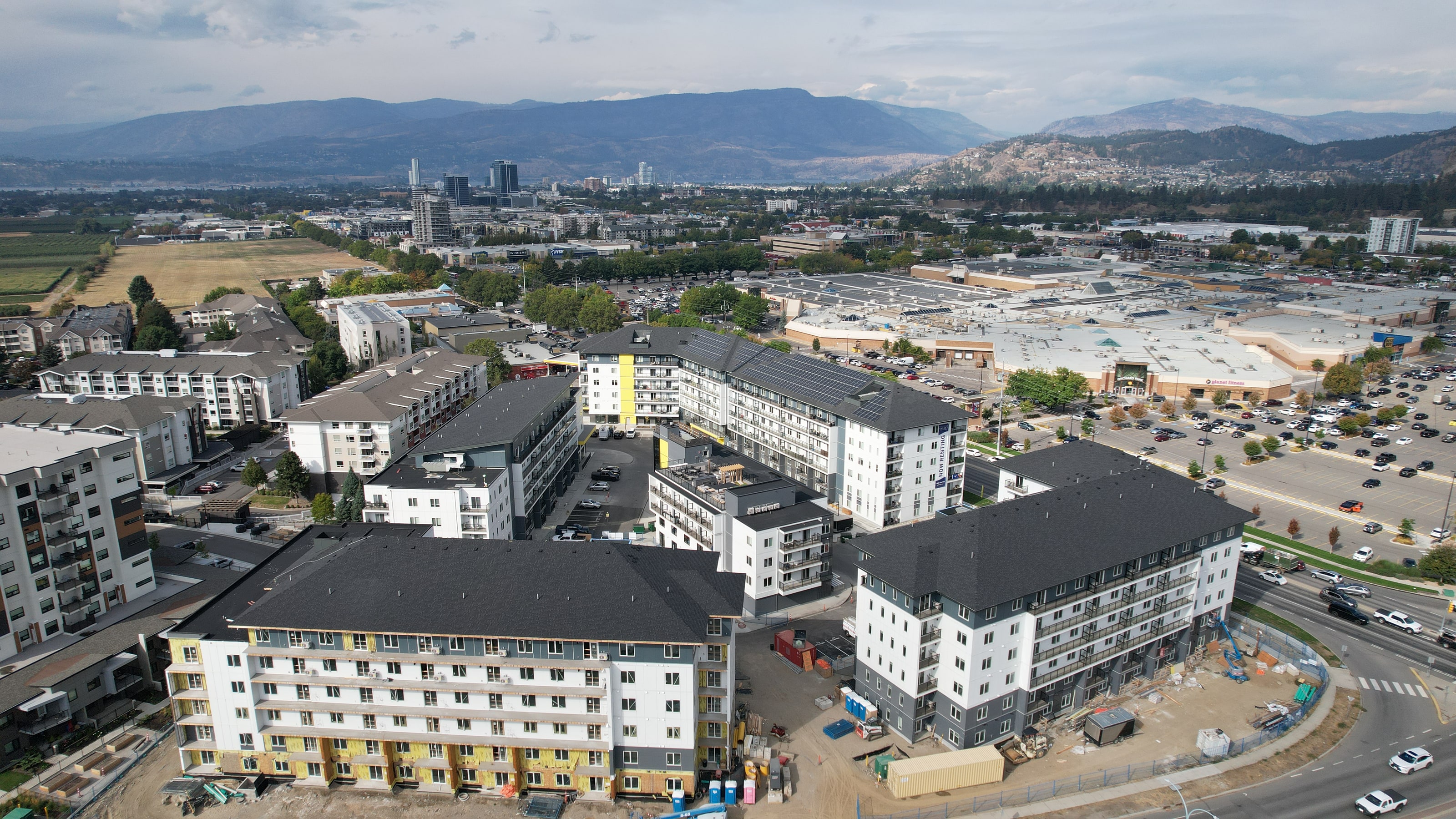The multi-unit complex finished, its roofs done, the city beyond