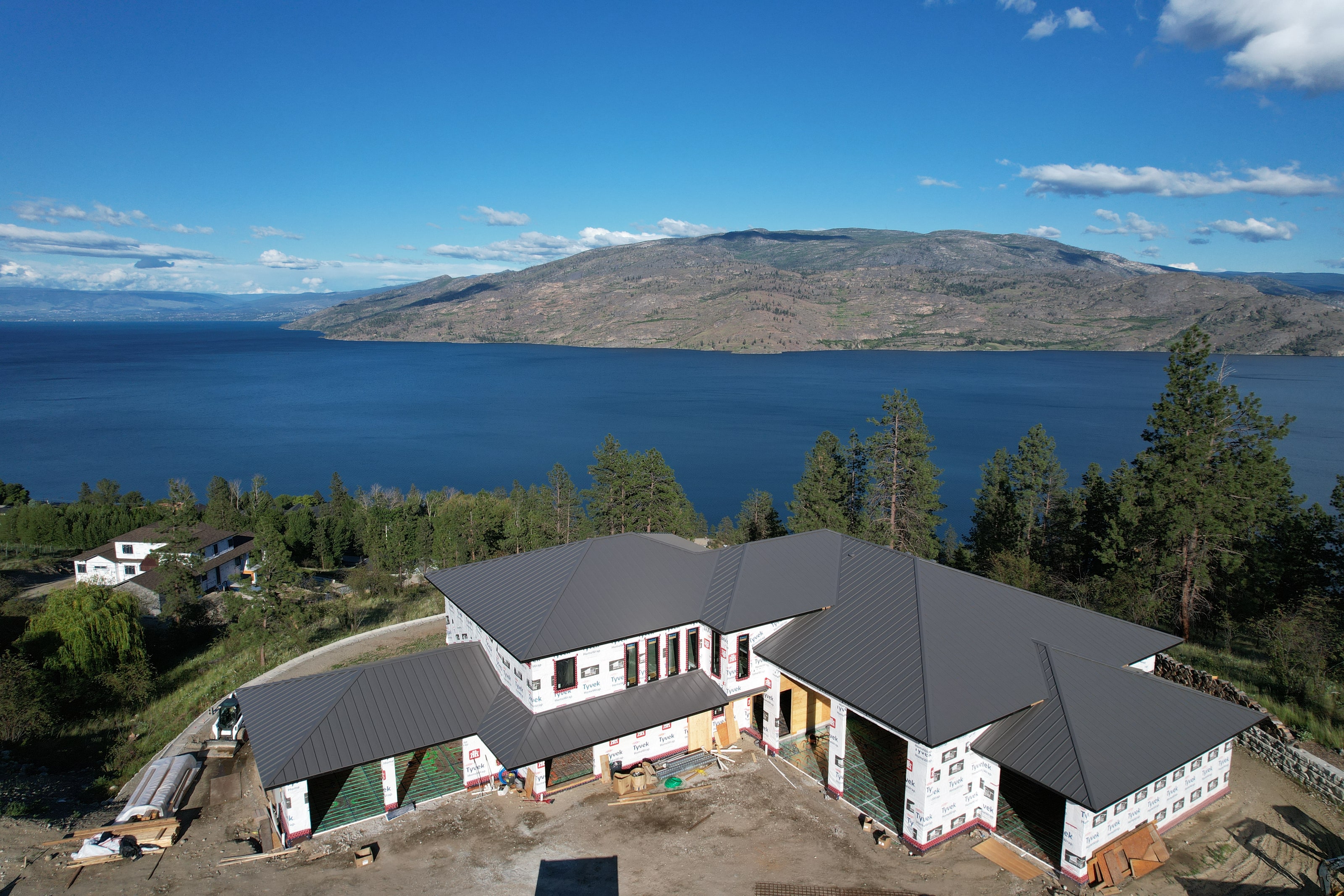 The new home and its charcoal metal roof above Okanagan Lake