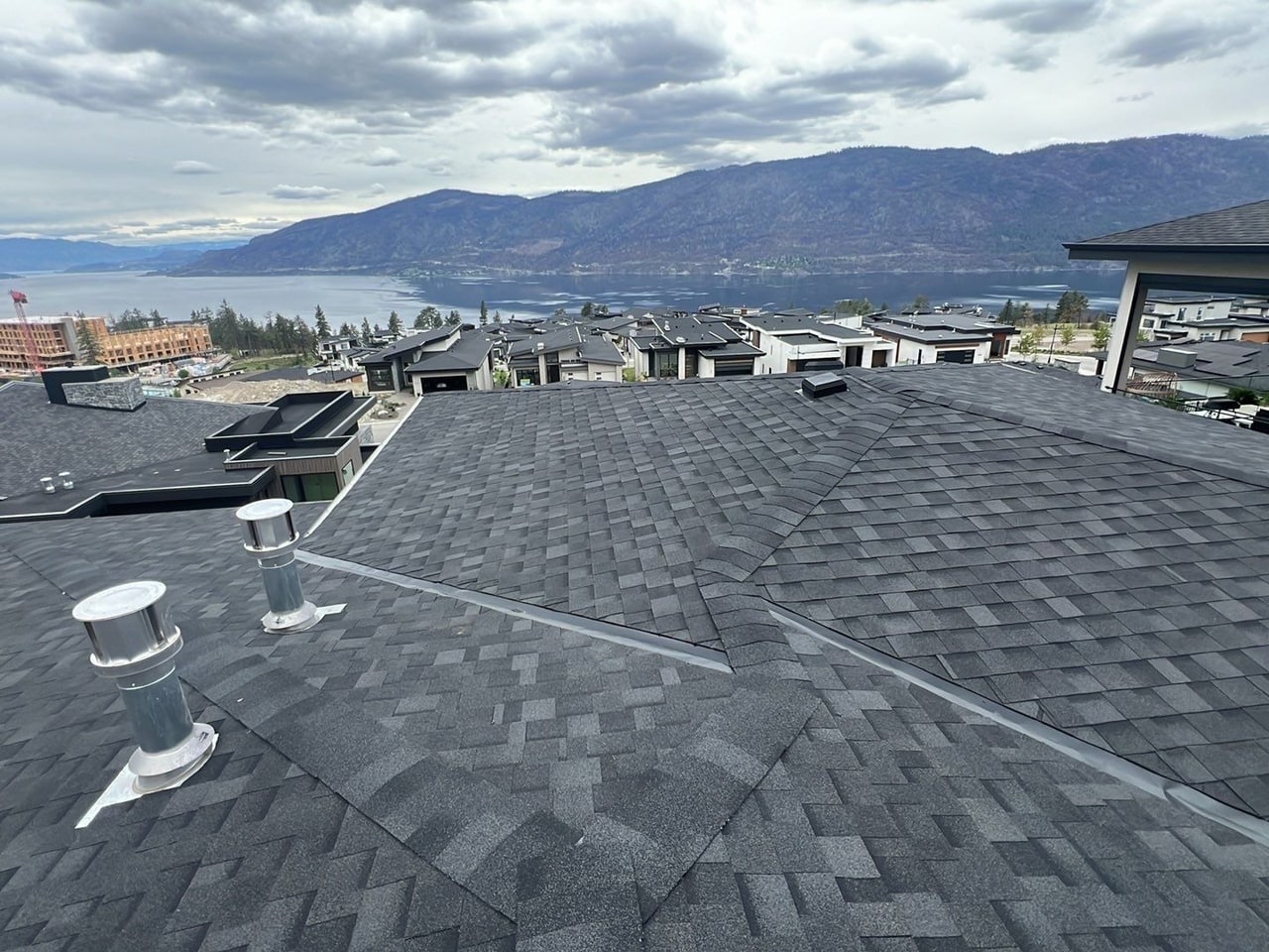 New charcoal shingles on a new home, the lake and the hills beyond
