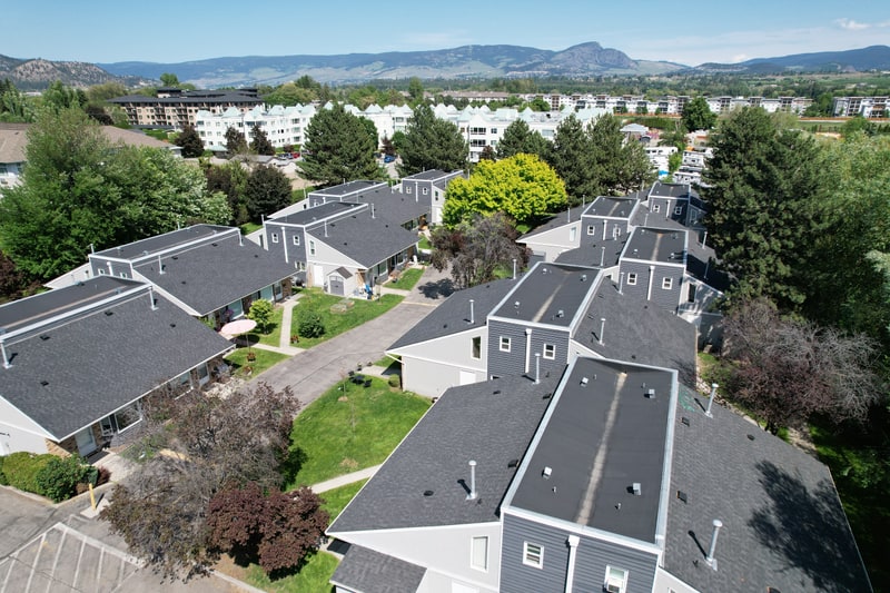 A townhome complex with new shingle roofs, seen from the air